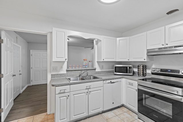 kitchen featuring ceiling fan, sink, stainless steel appliances, light hardwood / wood-style floors, and white cabinets