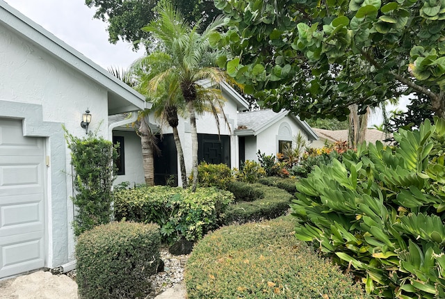 exterior space with a garage and stucco siding