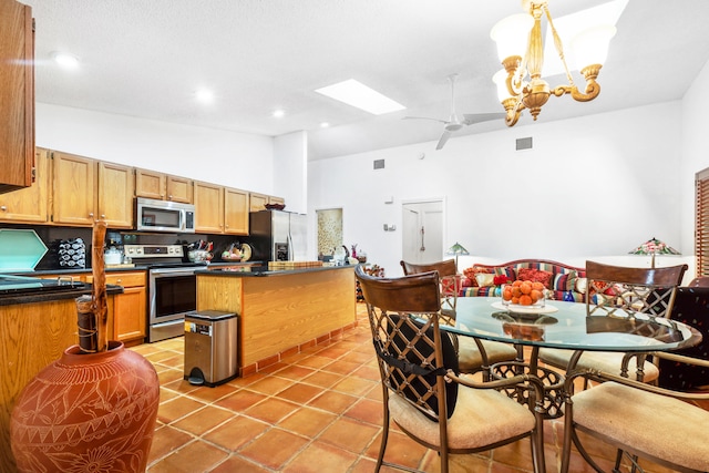 kitchen with appliances with stainless steel finishes, tasteful backsplash, light tile patterned floors, hanging light fixtures, and lofted ceiling