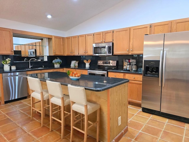 2450 Riviera Dr, Delray Beach, FL 33445 - kitchen featuring light tile patterned flooring, a sink, stainless steel appliances, vaulted ceiling, and dark countertops