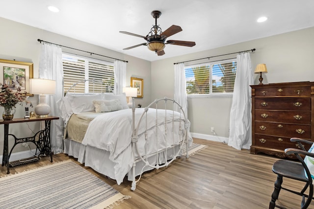 bedroom featuring multiple windows, ceiling fan, and light hardwood / wood-style flooring