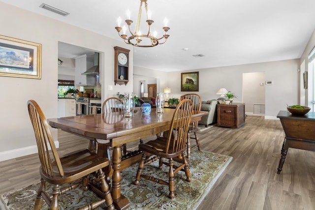 dining space featuring a chandelier, hardwood / wood-style floors, and a healthy amount of sunlight