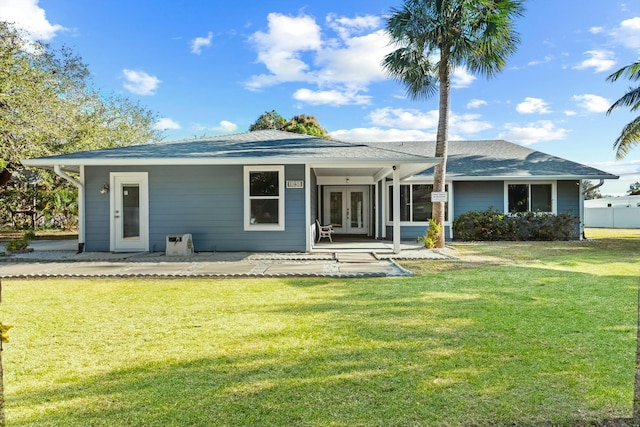 back of property featuring a yard and french doors