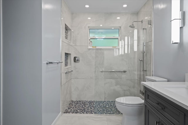 bathroom featuring tiled shower, vanity, and toilet