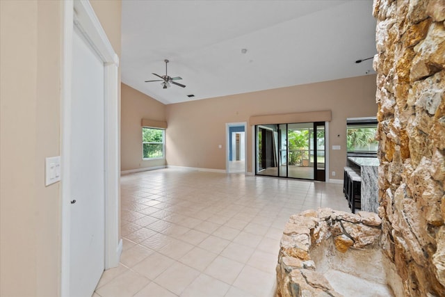 unfurnished living room with ceiling fan, light tile patterned flooring, and high vaulted ceiling