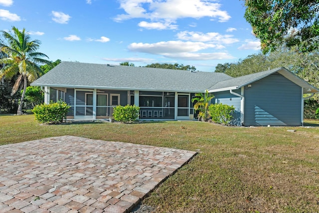 rear view of house with a lawn, a patio area, and a sunroom