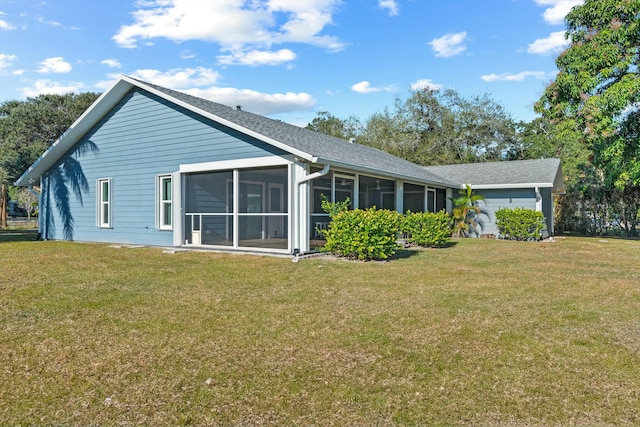 rear view of property featuring a yard and a sunroom