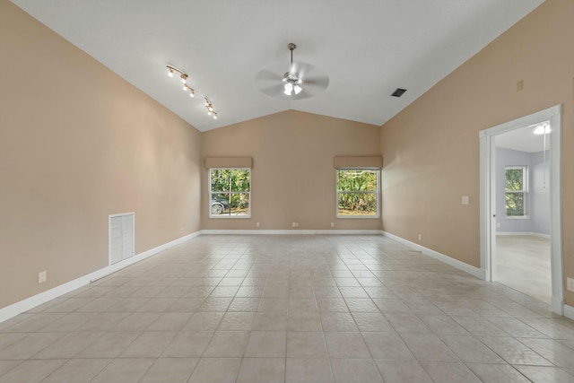 tiled empty room with rail lighting, ceiling fan, and lofted ceiling