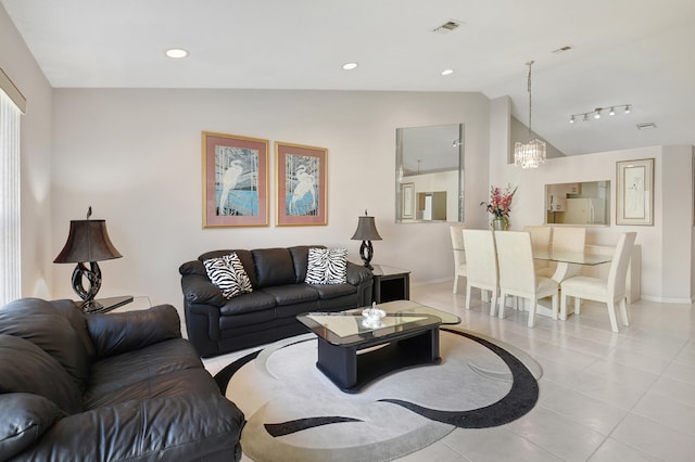 tiled living room with lofted ceiling and a notable chandelier