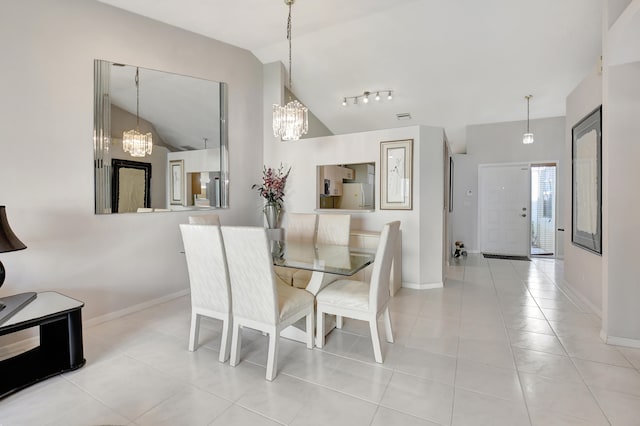 tiled dining room with rail lighting and vaulted ceiling