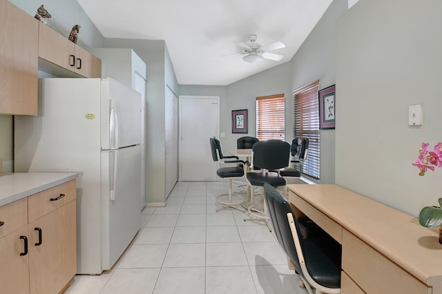 kitchen with ceiling fan, light brown cabinetry, light tile patterned floors, and white refrigerator