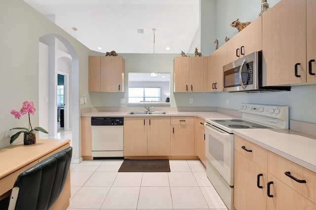 kitchen with white appliances, light tile patterned floors, light brown cabinets, and sink