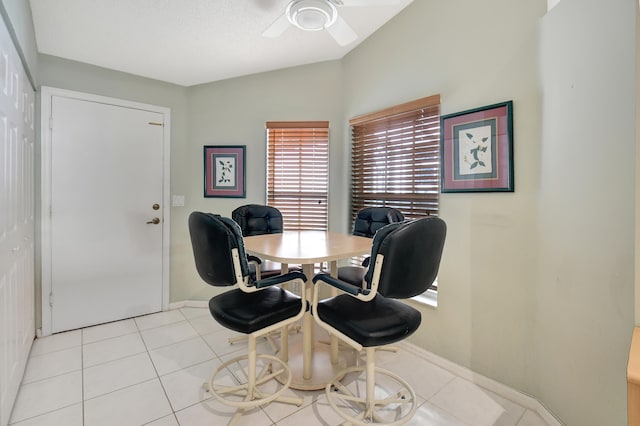 tiled dining space with vaulted ceiling and ceiling fan