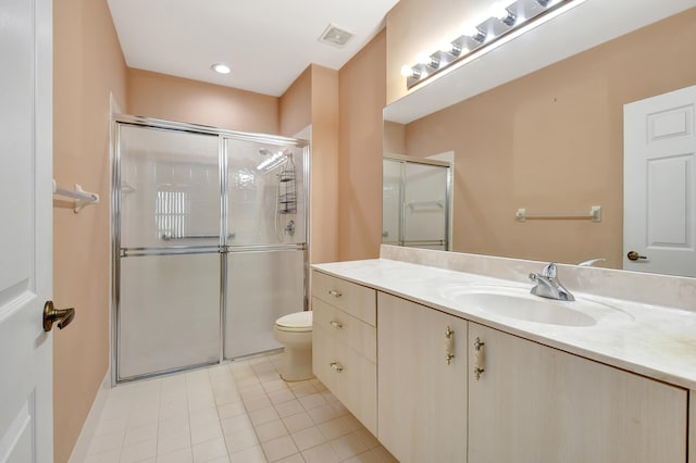 bathroom featuring vanity, a shower with shower door, toilet, and tile patterned floors