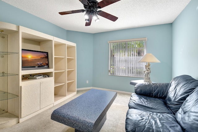 carpeted living room with ceiling fan and a textured ceiling