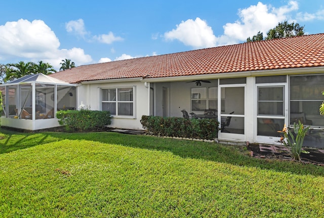 rear view of property with a sunroom and a lawn