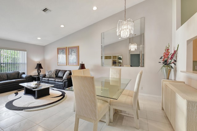 tiled dining area featuring a chandelier and vaulted ceiling