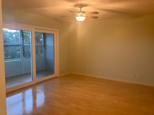 unfurnished room with ceiling fan, a textured ceiling, and light hardwood / wood-style flooring