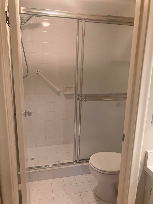 bathroom featuring vanity, a shower with shower door, toilet, and tile patterned floors