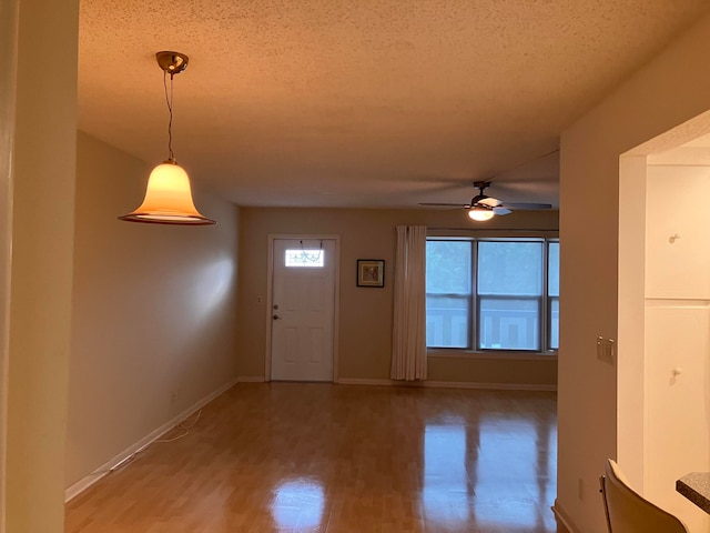 foyer featuring a textured ceiling, a healthy amount of sunlight, wood-type flooring, and ceiling fan