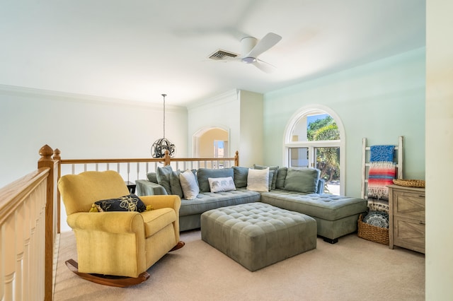 living room featuring ceiling fan, ornamental molding, and light colored carpet