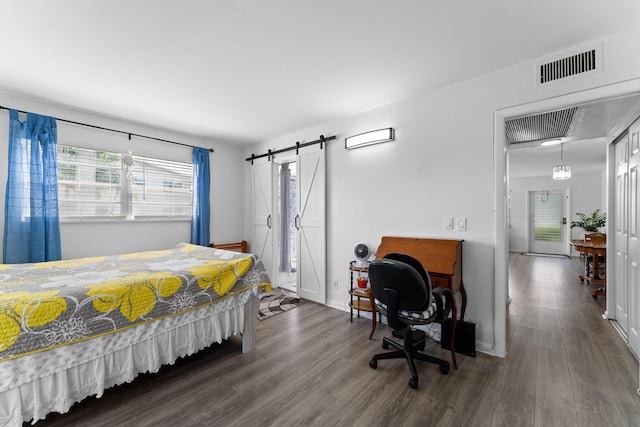 bedroom featuring hardwood / wood-style floors and a barn door