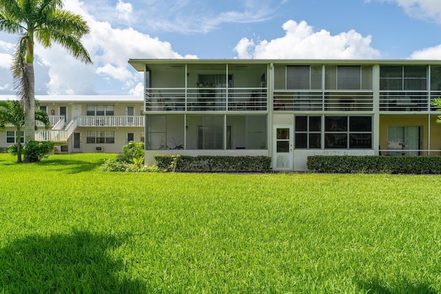 back of property featuring stucco siding and a yard