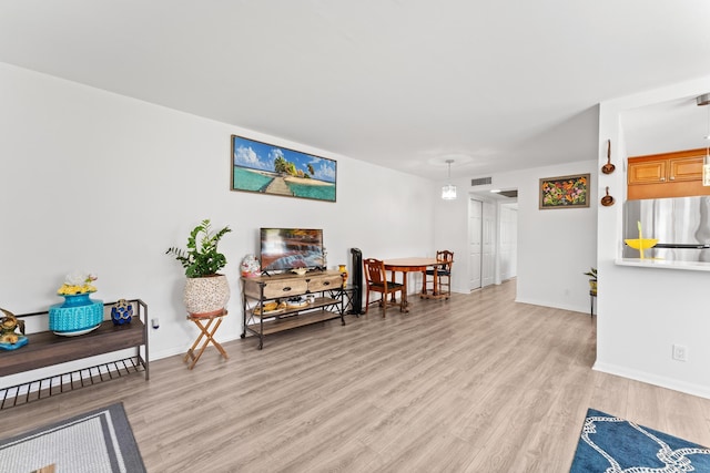 sitting room with baseboards, visible vents, and light wood-style flooring