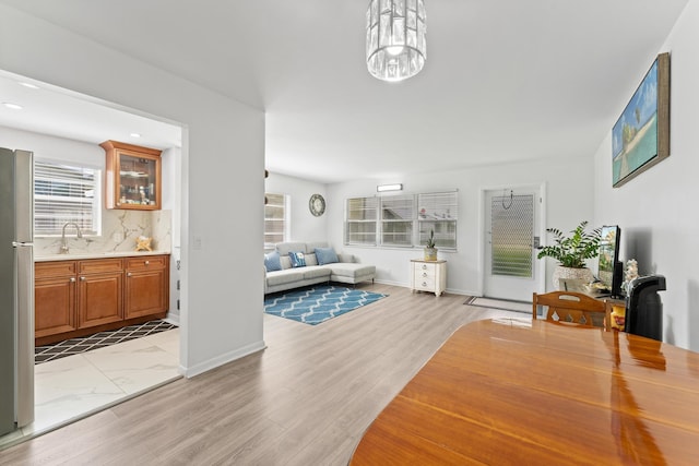 living room with sink, light hardwood / wood-style flooring, and a chandelier