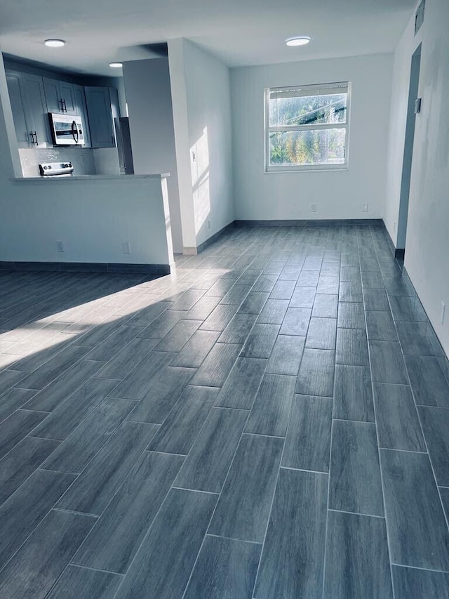 unfurnished living room featuring wood finish floors and visible vents