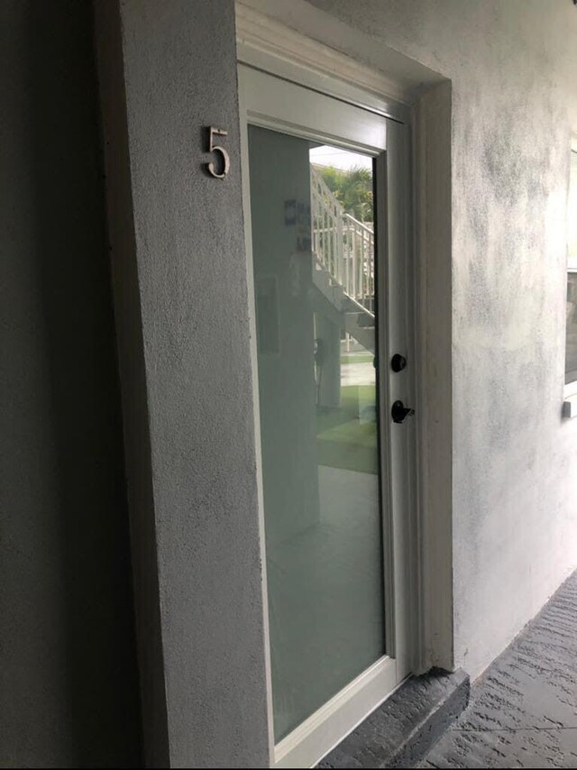 entrance to property featuring stucco siding