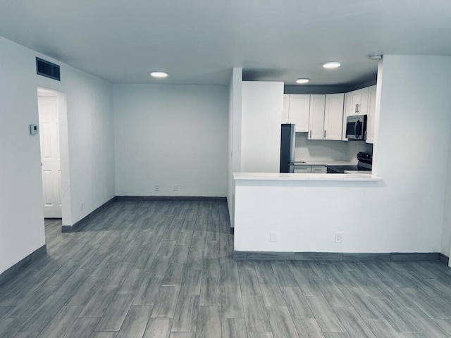 kitchen featuring white cabinetry, visible vents, wood tiled floor, and appliances with stainless steel finishes