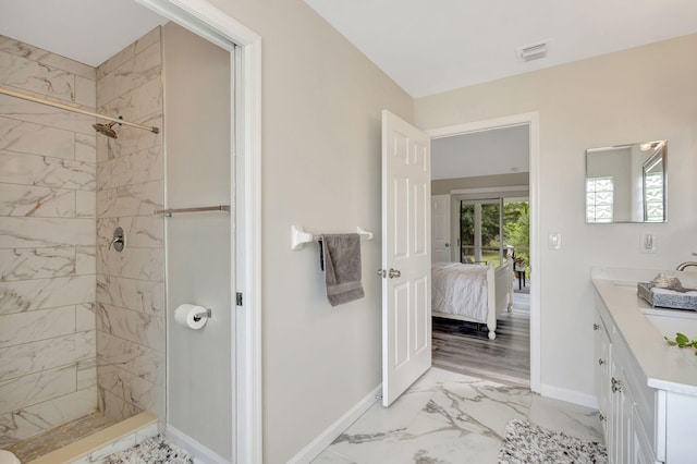 bathroom with hardwood / wood-style flooring, a tile shower, and vanity