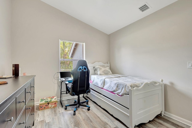 bedroom with vaulted ceiling and light hardwood / wood-style floors