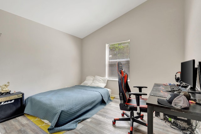 bedroom with vaulted ceiling and light hardwood / wood-style flooring