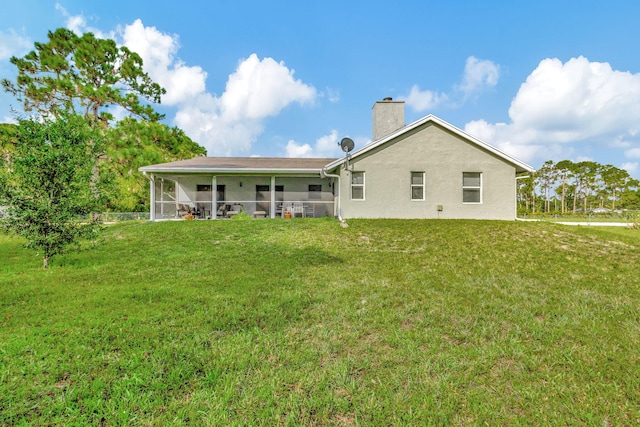 rear view of house featuring a lawn