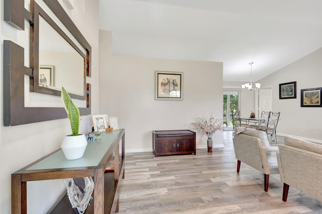 interior space with an inviting chandelier, light hardwood / wood-style flooring, and lofted ceiling