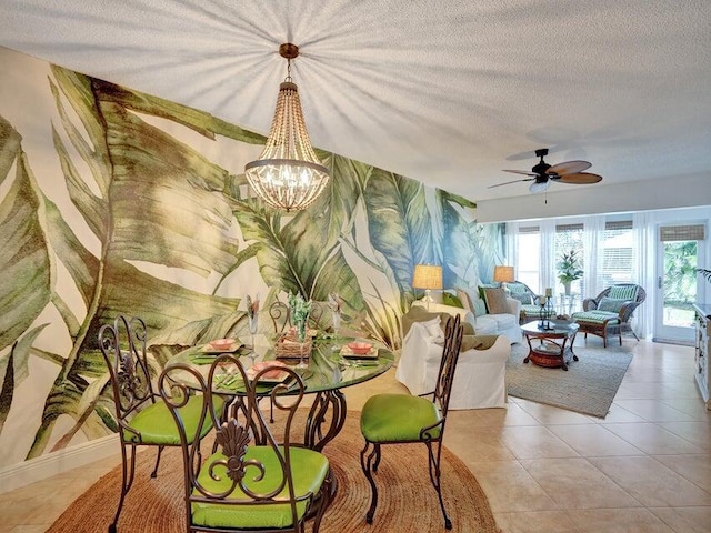 dining room with a textured ceiling, ceiling fan with notable chandelier, and light tile patterned floors