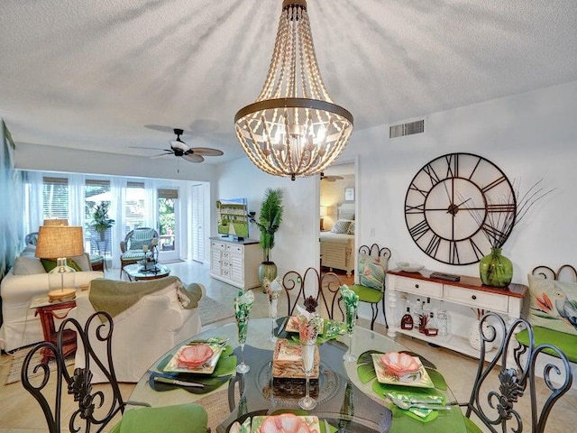 dining space with a textured ceiling and ceiling fan with notable chandelier