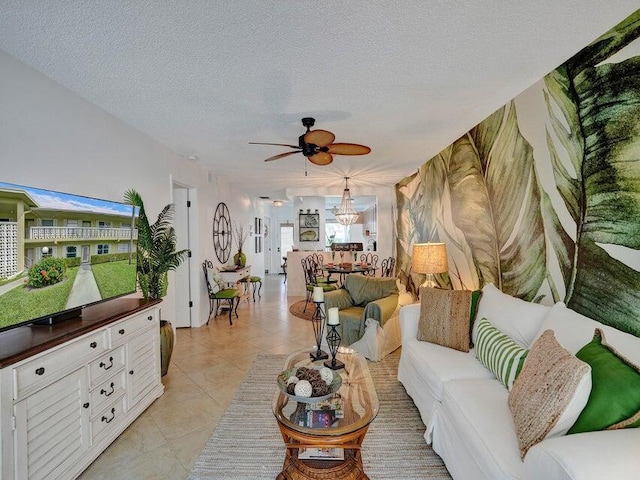 living room with a textured ceiling, ceiling fan with notable chandelier, light tile patterned floors, and a wealth of natural light