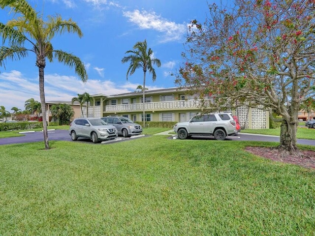 view of parking / parking lot with a lawn