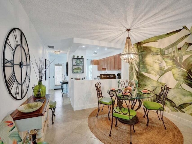 tiled dining room featuring a textured ceiling and a chandelier