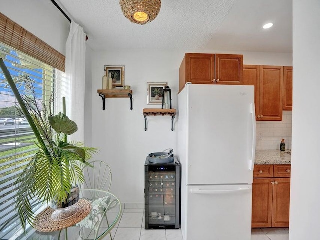 kitchen with light tile patterned flooring, white refrigerator, decorative backsplash, a textured ceiling, and beverage cooler