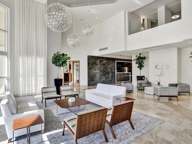 living room featuring visible vents, marble finish floor, and a chandelier