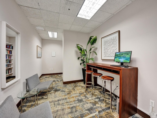 home office featuring a drop ceiling and baseboards