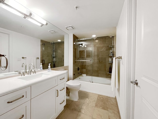 full bathroom with tile patterned flooring, shower / bath combination with glass door, toilet, and vanity