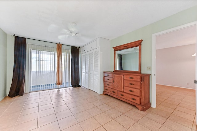 unfurnished bedroom with ceiling fan, light tile patterned flooring, and a closet