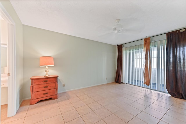 unfurnished room with ceiling fan and light tile patterned floors