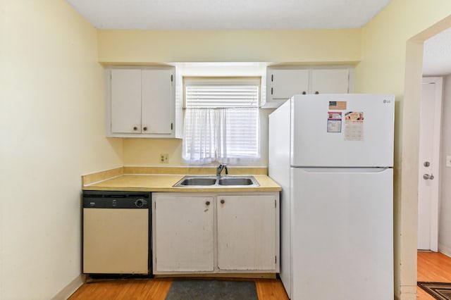 kitchen with white cabinets, white appliances, sink, and light hardwood / wood-style flooring