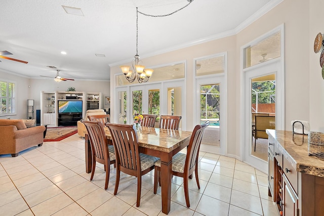 dining area featuring ornamental molding, ceiling fan with notable chandelier, and light tile patterned floors